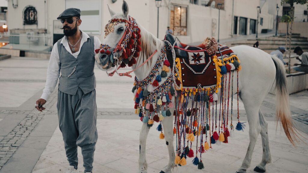 Man walks a decorated horse.