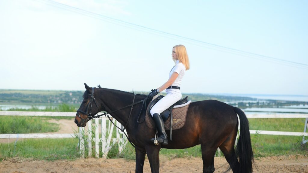 woman riding horse during daytime