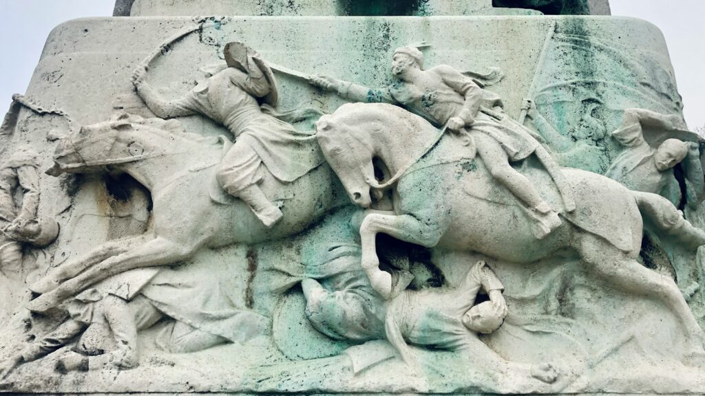 a statue of a man riding a horse next to a statue of a man on horse