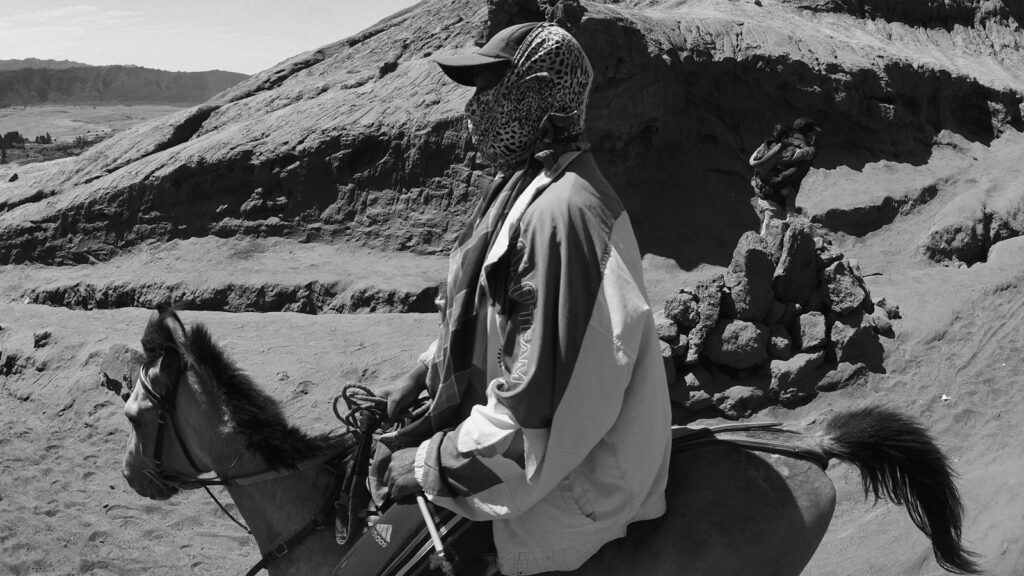 grayscale photography of man riding horse