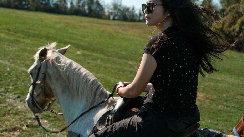 A woman riding on the back of a white horse
