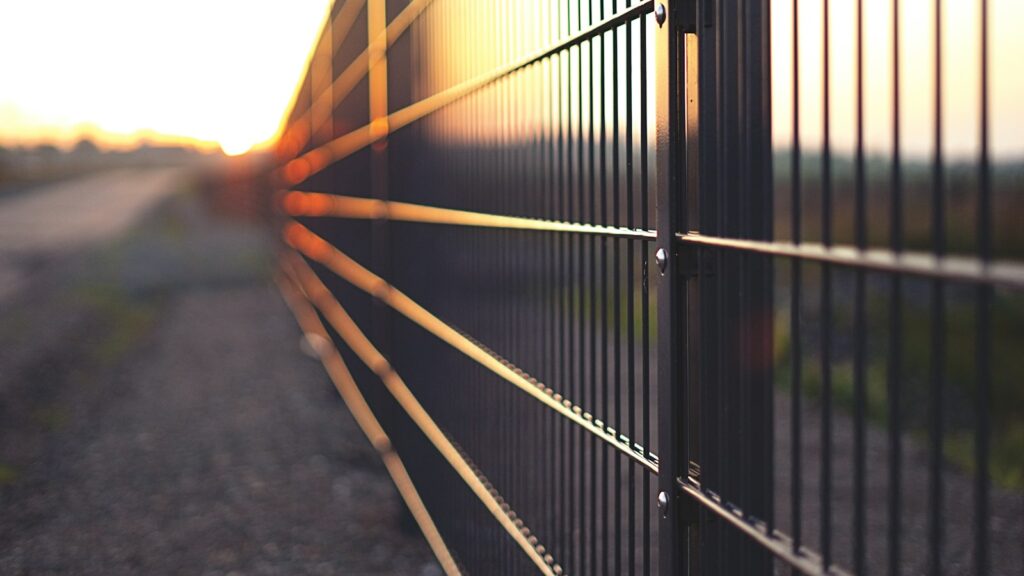 black metal fence during sunset