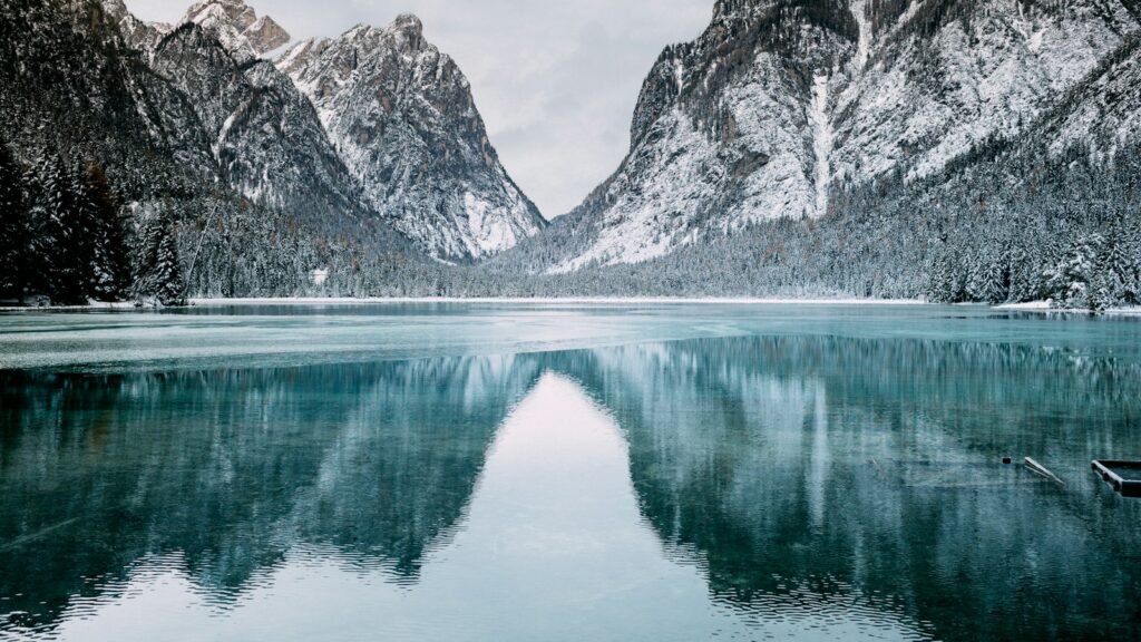 body of water and snow-covered mountains during daytime