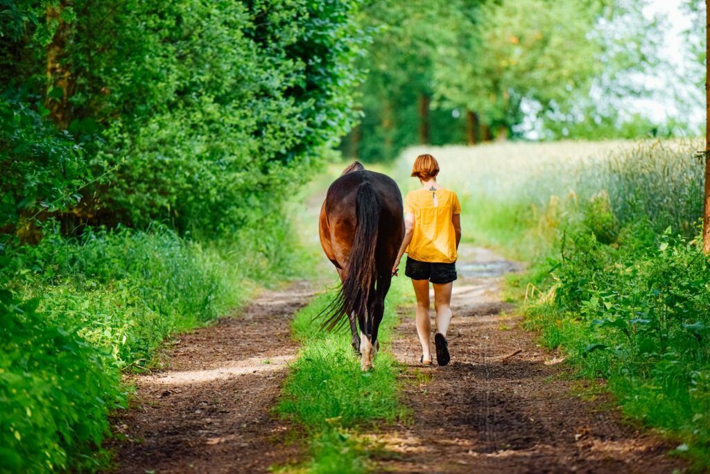 Woman walking beside horse