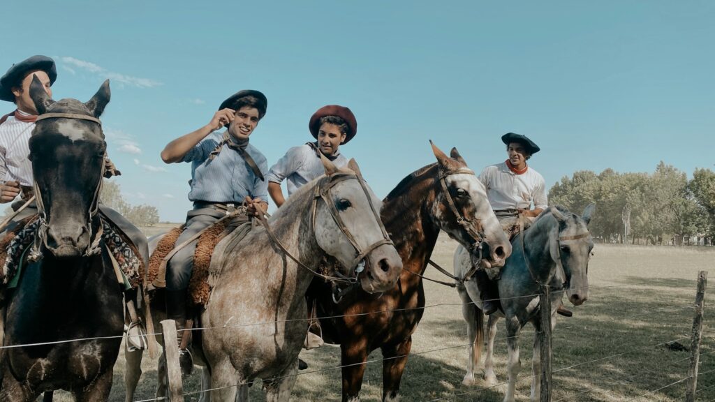 people riding horses on green grass field during daytime