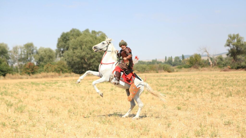 Man in period costume riding rearing horse in Kütahya, Türkiye.