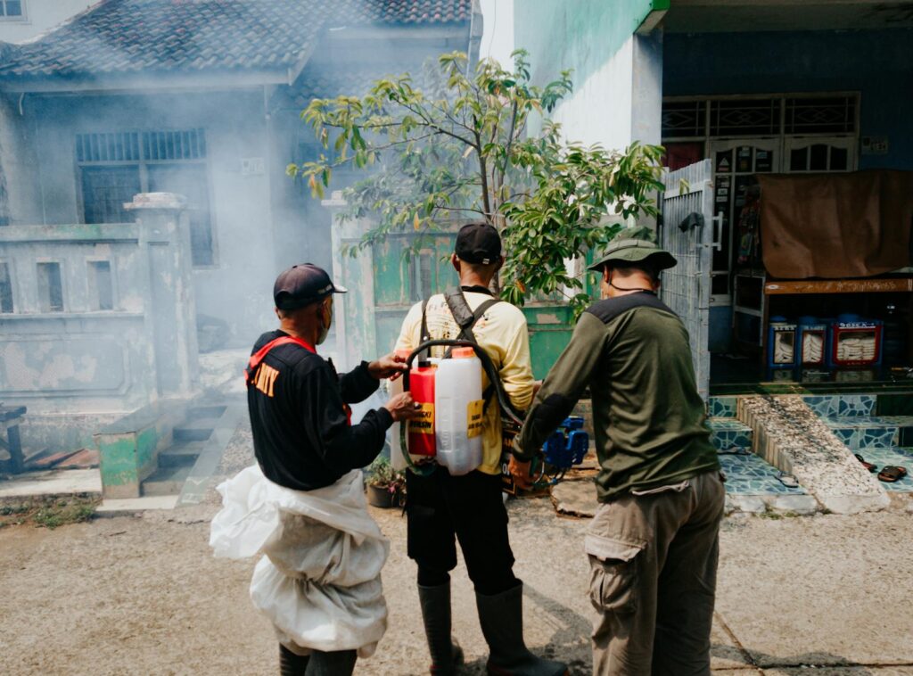 Three men engaged in street fumigation in Cibinong, Indonesia.