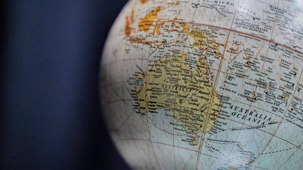 A detailed close-up of a vintage globe focusing on Australia and Oceania, highlighting geographical textures.