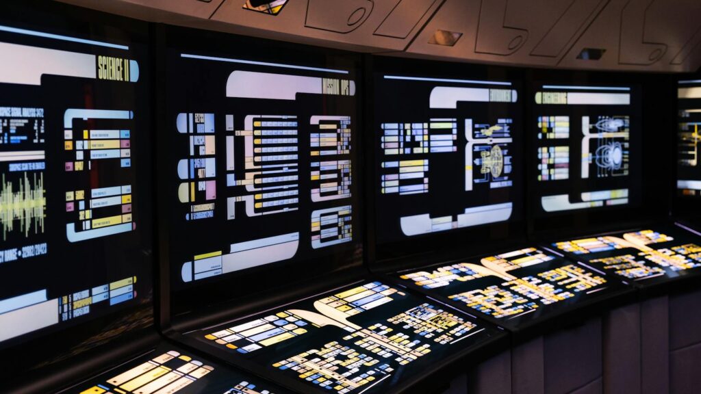 A high-tech command center with illuminated digital screens in a futuristic setting.