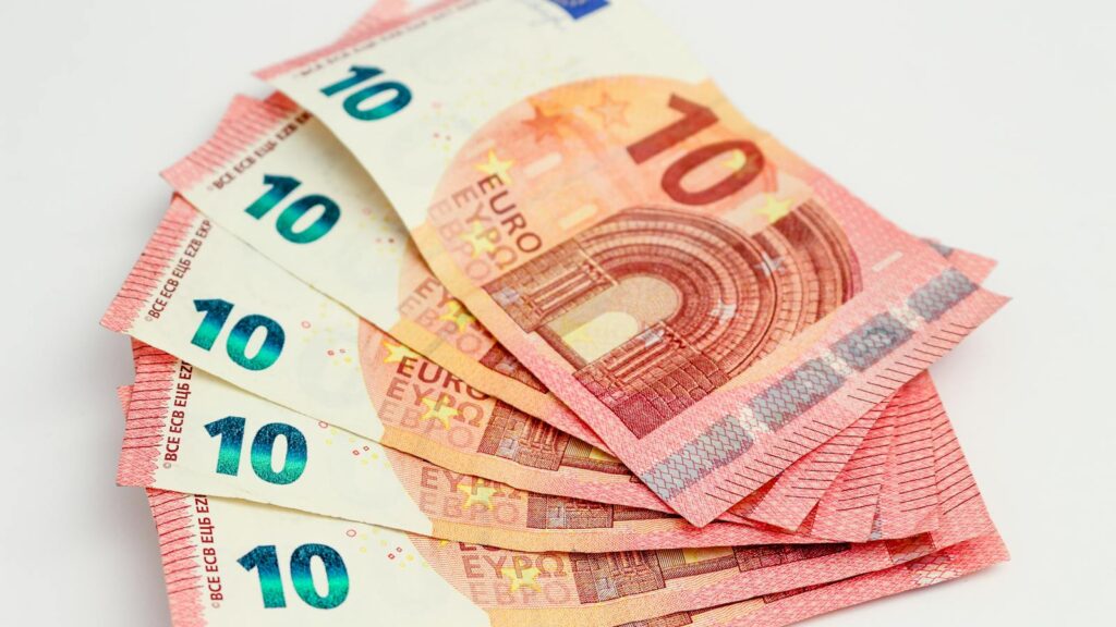Close-up of a fan of 10 euro banknotes on a clean white background, showcasing European currency.