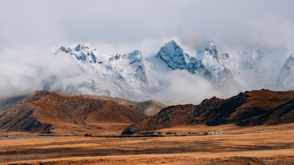 brown and white mountains under white clouds during daytime
