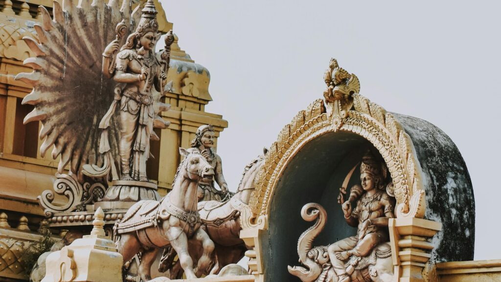 Intricate sculptures depicting Hindu deities adorn a temple facade, showcasing rich cultural artistry and spirituality.