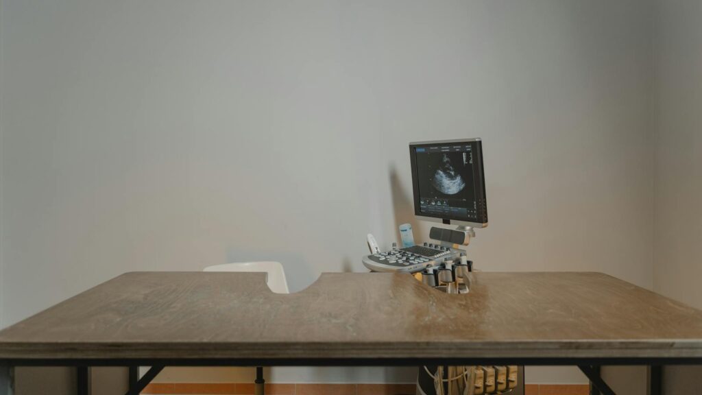 Ultrasound machine setup in a minimalist medical office for patient examinations.