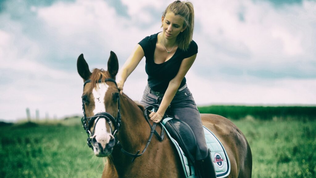 girl in black shirt riding brown horse during daytime
