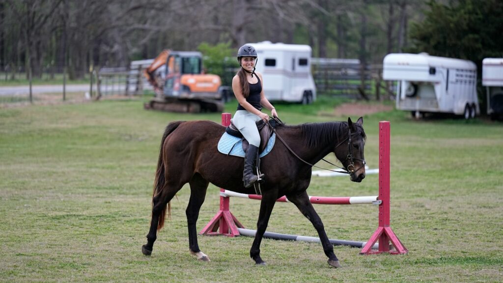 a woman riding on the back of a brown horse