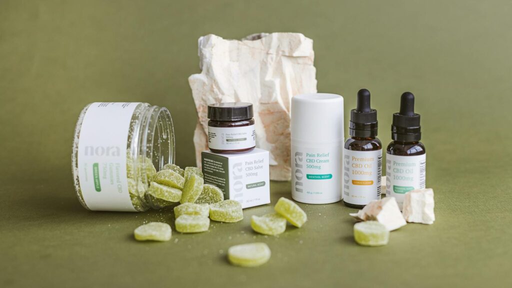 Close-up of CBD products including oils, edibles, and creams on a green background.