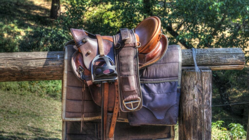 brown leather horse saddle on fence