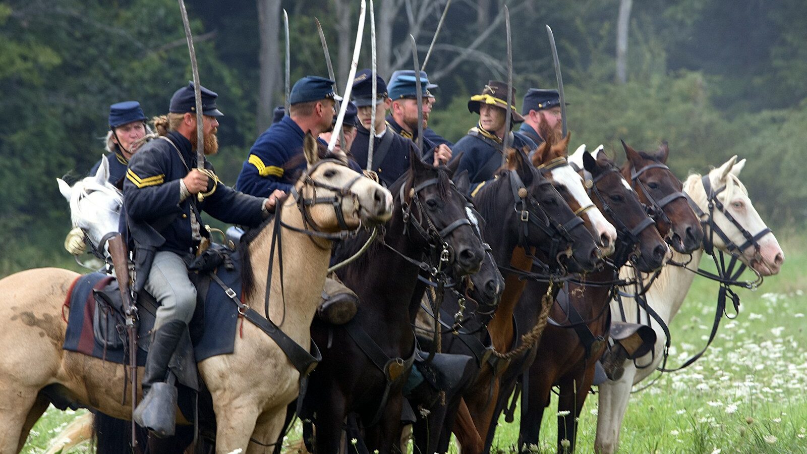 men riding horses on green grass field during daytime
