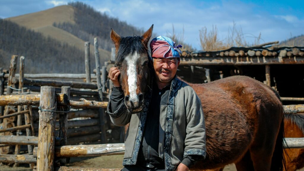 a man standing next to a brown horse