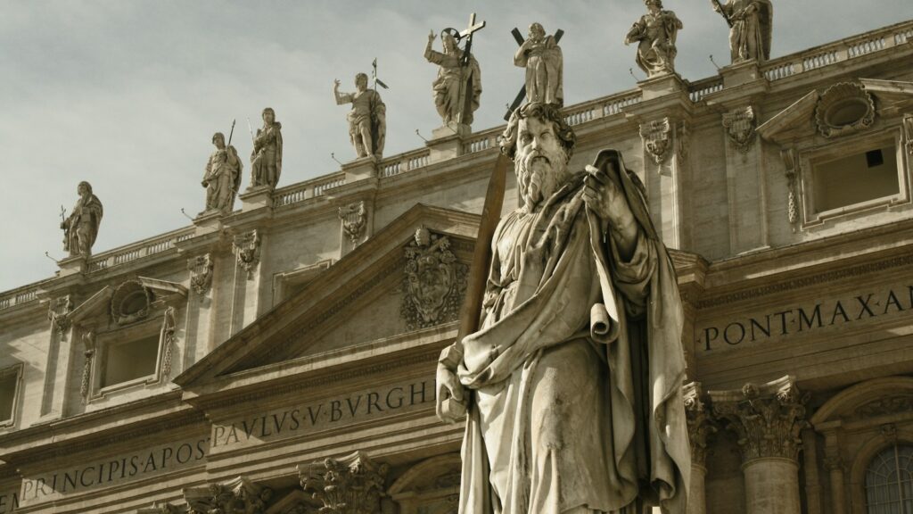 monument with statuettes on top building at daytime