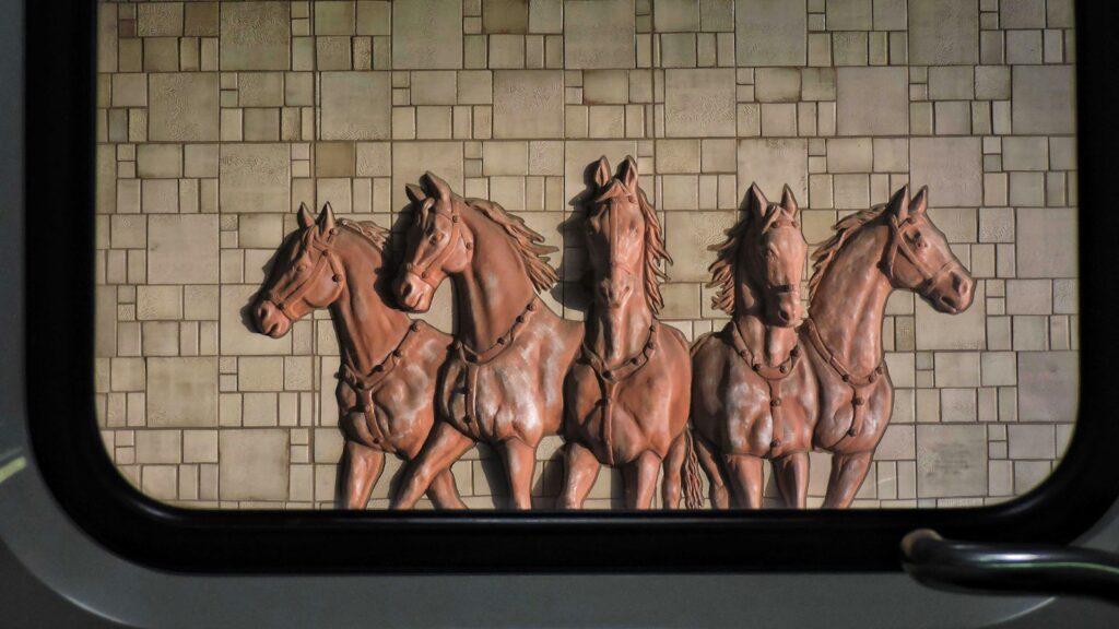a group of horses standing next to a brick wall