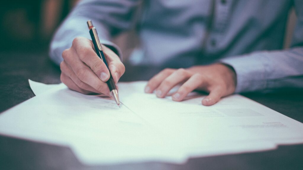 man writing on paper