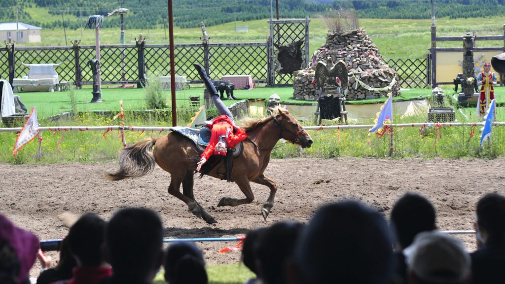 people riding horses on green grass field during daytime
