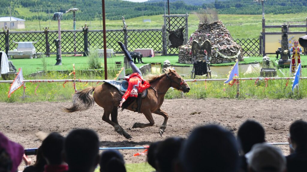 people riding horses on green grass field during daytime