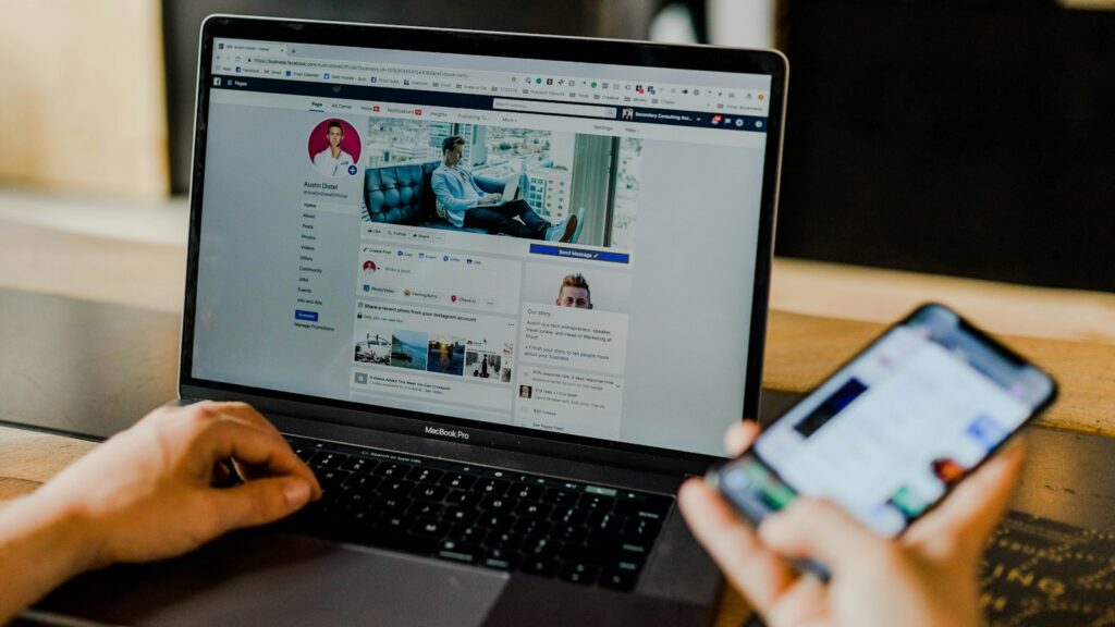 person using both laptop and smartphone
