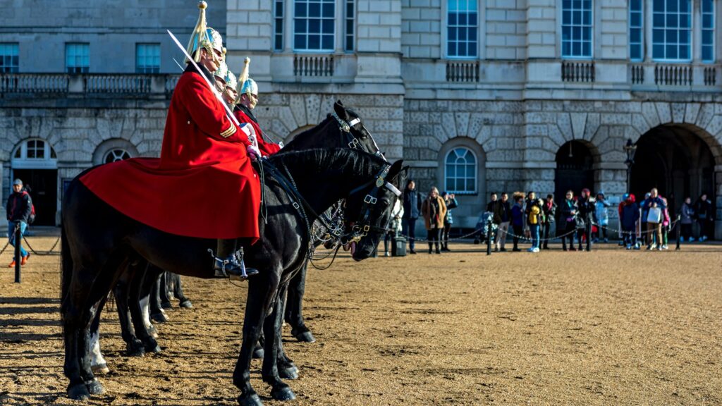 man in red and white long sleeve shirt riding black horse during daytime