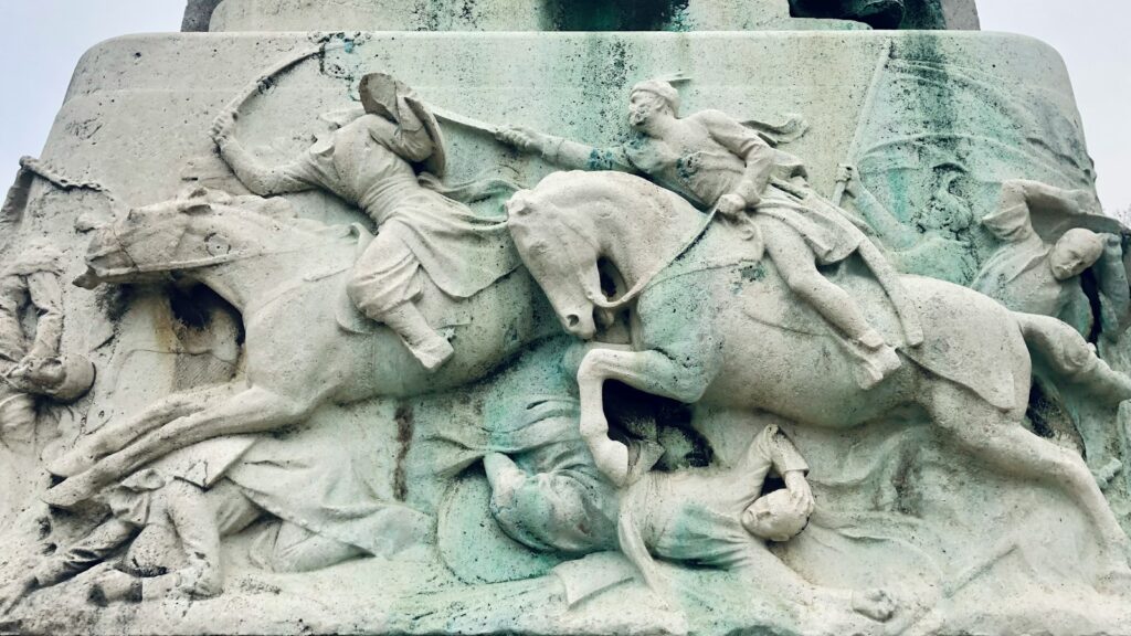 a statue of a man riding a horse next to a statue of a man on