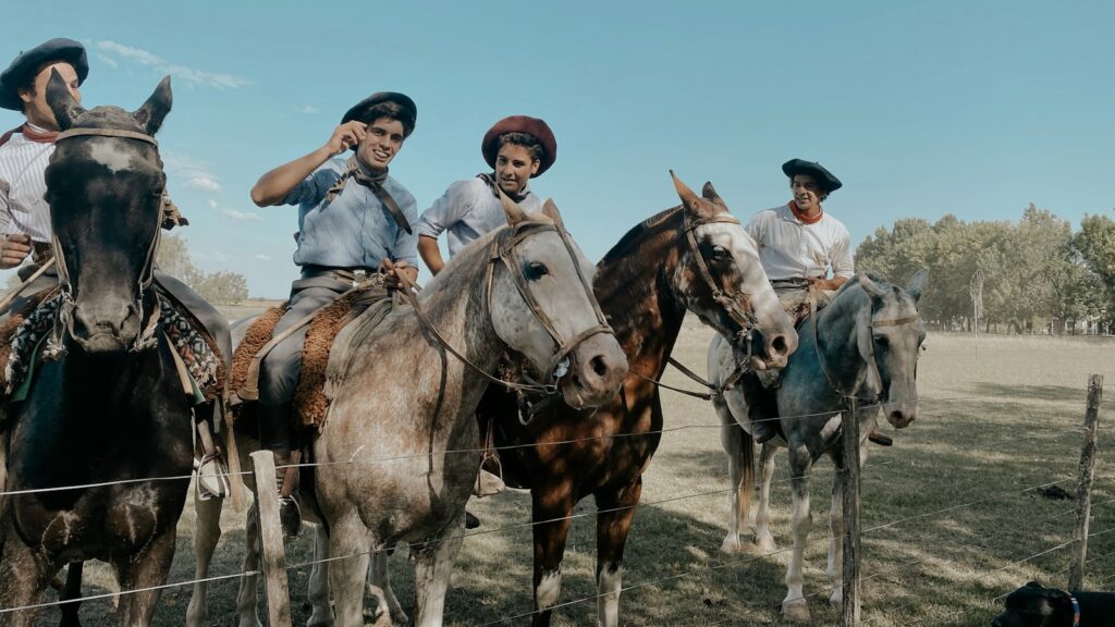 people riding horses on green grass field during daytime